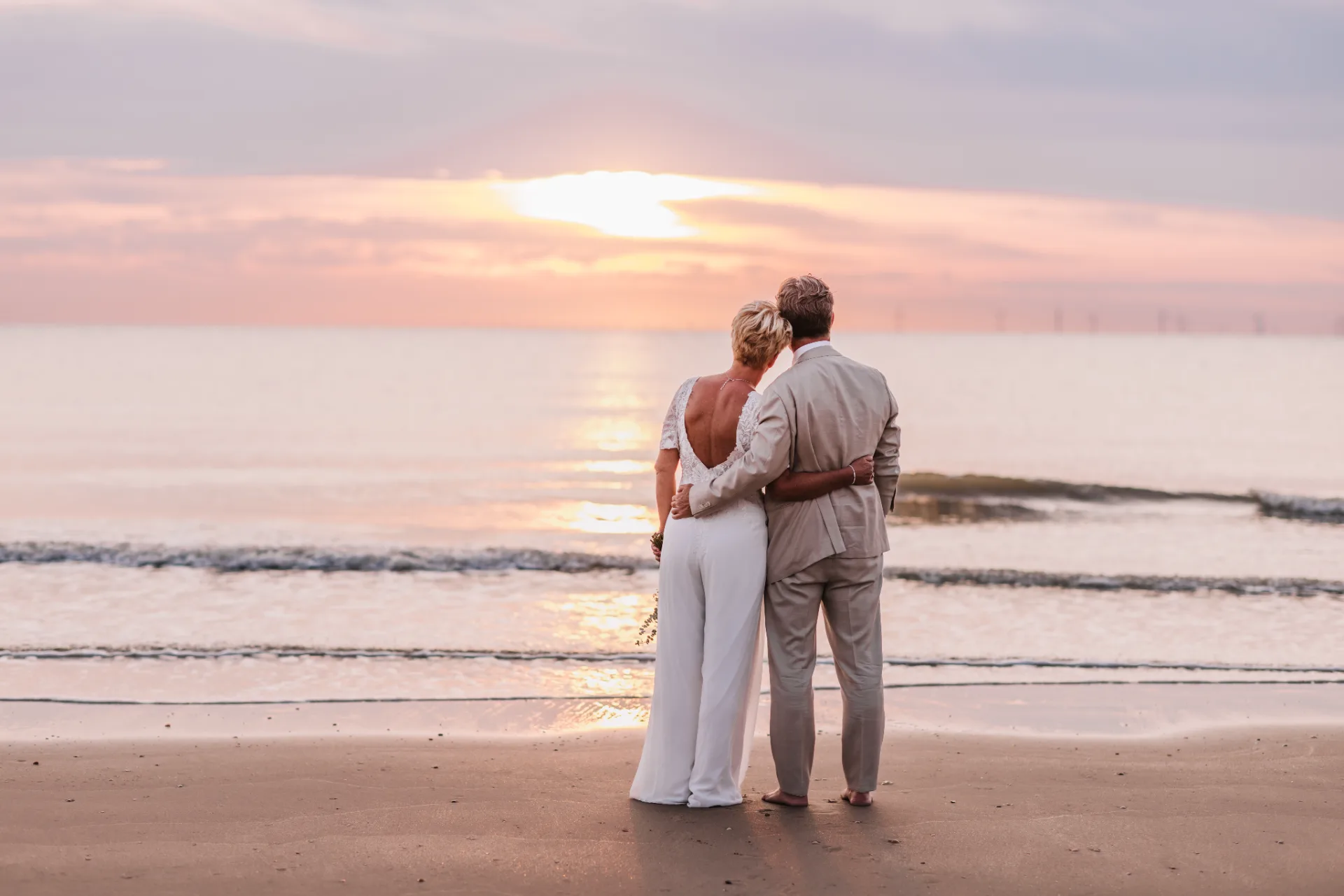 Bruidspaar bij zonsondergang op het strand