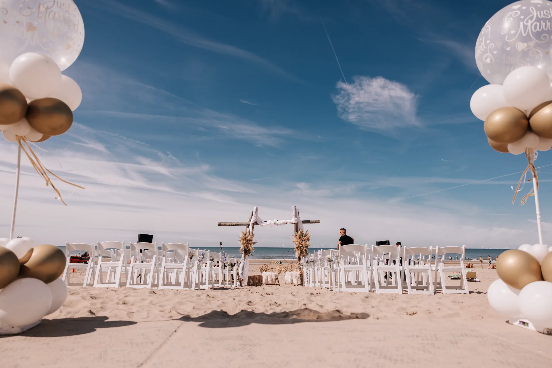 Bohemian ceremonie op het strand met drijfhout en bloemen